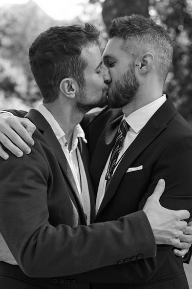 Grooms kissing while hugging each other.
