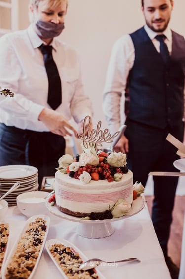 Hochzeitstorte mit dekorativem Liebes-Topper.