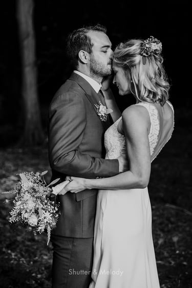 Groom kissing bride on the forehead.