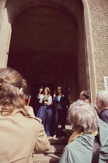 A newly married lesbian couple toasting with guests.