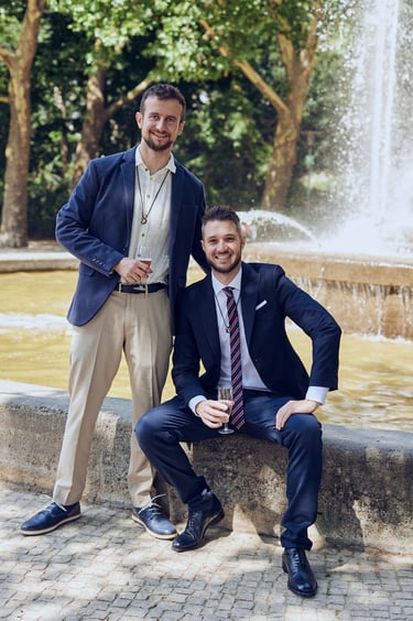 A portrait of two newlywed husbands in front of a fountain in Rudolph-Wilde-Park.