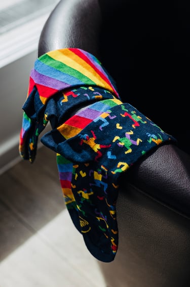 Rainbow socks laid out on an armchair.