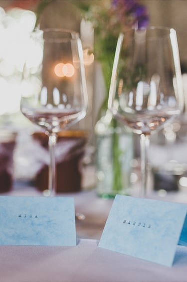 Blue name tags on a table with wine glasses.