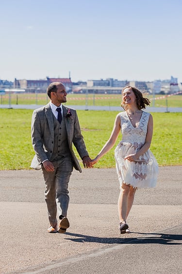 Bride and groom prancing on the tarmac of Tempelhof field.
