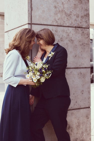 Two wives in love leaning on a column.