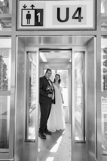 Bride and groom inside an elevator at an underground station.