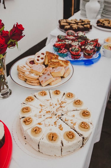 Walnut cake on a table next to other cakes.