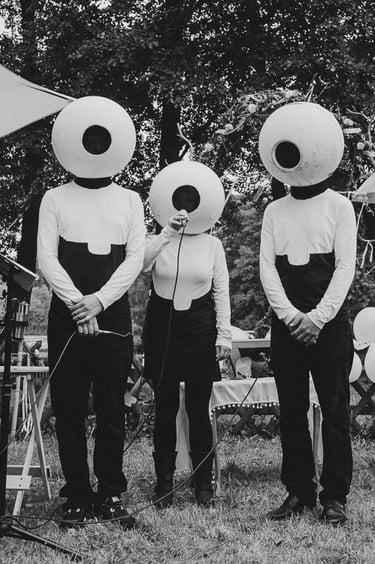 Three people dressed as aliens during a wedding ceremony.