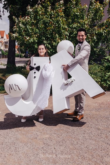 Bride and groom holding huge J A letters.