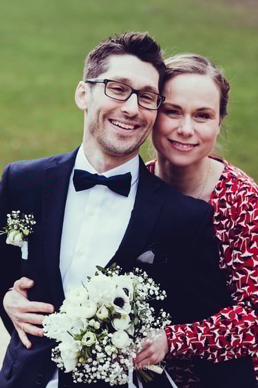 Bride hugging groom from behind.