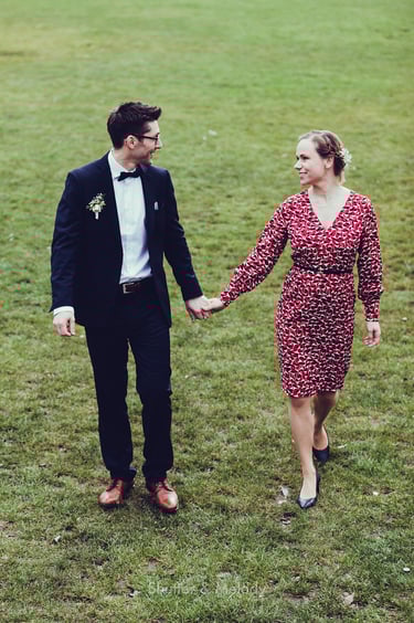 Bride and groom walking on grass.