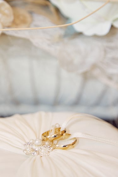 Wedding rings on a white pillow.