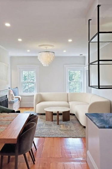 Open plan living area, curved bouclé sectional, capiz chandelier, cobalt quartzite bar, Charlestown Boston
