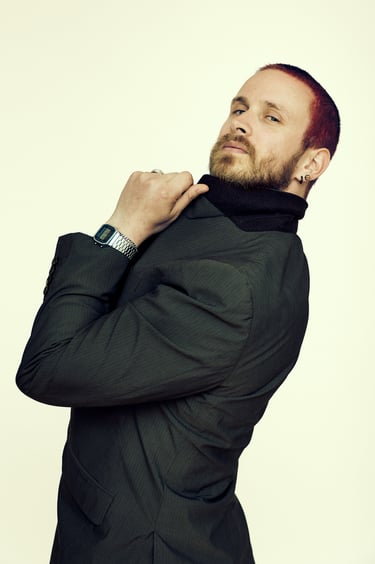 A confident red haired man in a suit.