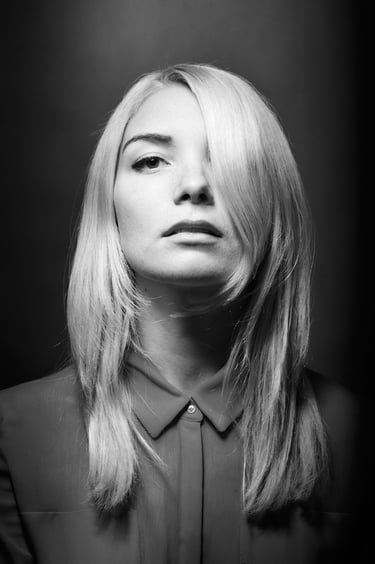 Ein schwarz-weißes Kopfbild einer jungen Frau mit blondem Haar.