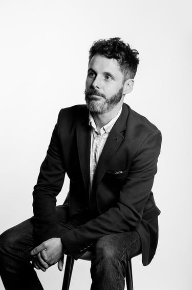A black and white portrait of a business man in a suit jacket.