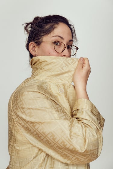 A suspicious woman wearing a yellow Wendi coat.