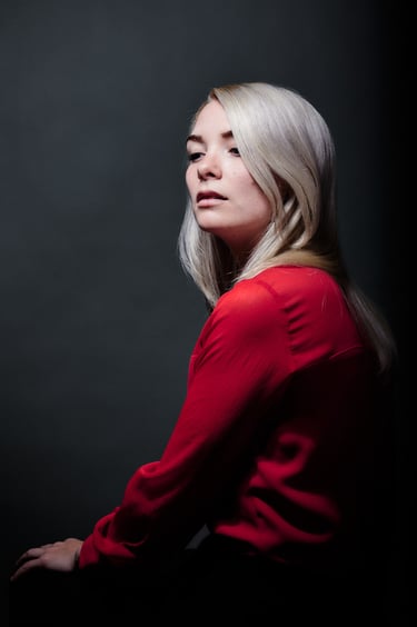 Attraktive blonde Frau, die über ihre Schulter nach unten schaut.