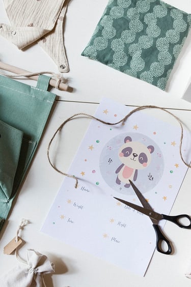 Ein Flatlay mit einem Kissen, Öl, einem Lätzchen, einer Decke und Wandtaschen.