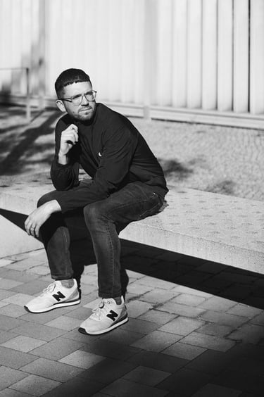 Nicholas Potter sitting on a stone bench in Berlin.