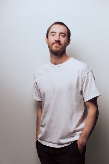 Ein Mann mit weißem Hemd, fotografiert in einem Studio.