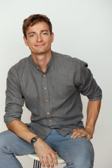 Portrait of a young man sitting on a chair.