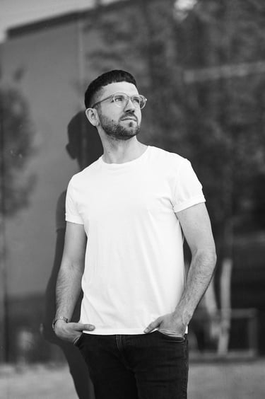 A black and white portrait of man wearing a white t-shirt.