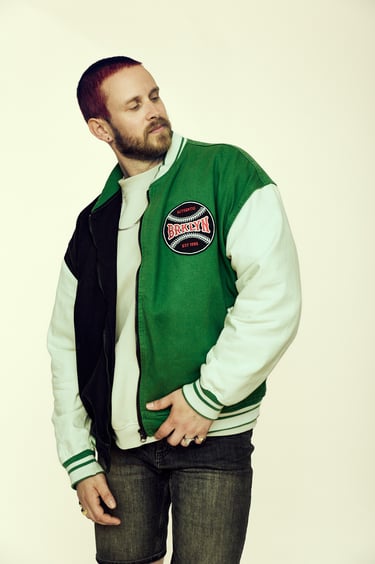 Ein Mann mit einer grünen Baseballjacke.