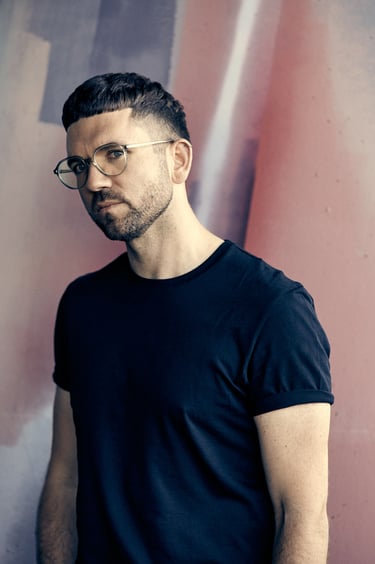 Portrait of journalist Nicholas Potter with a painted wall in the background.