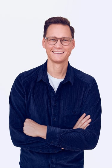 A happy man in a blue corduroy shirt.