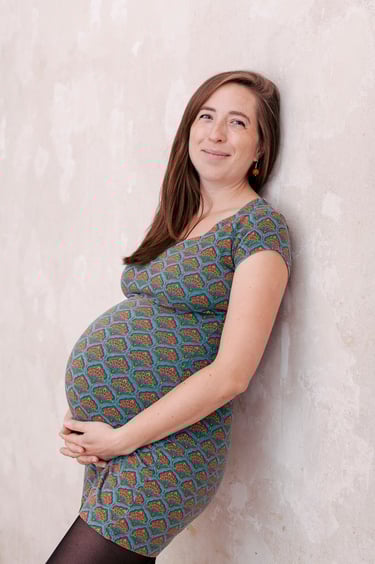 A pregnant woman in a tight blue dress with a print.