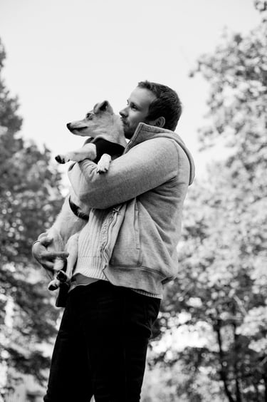 Steve Devonas holding his dog wearing a hoodie.