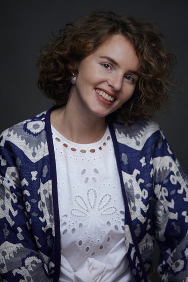 Das Porträt einer Frau, die ein volkstümlich inspiriertes weißes Hemd trägt.