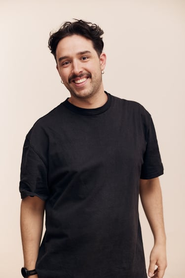 A man in a black shirt smiling.