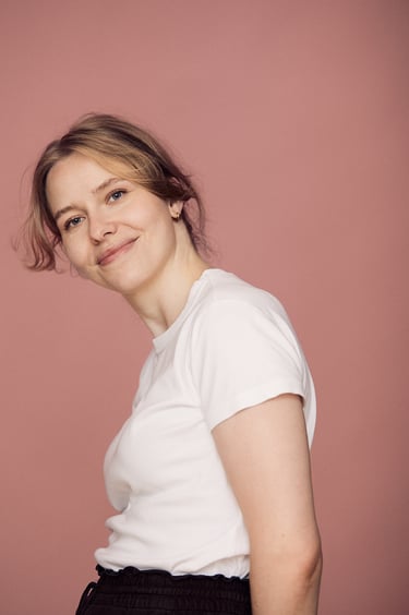 A woman in a white t-shirt photographed in a studio.