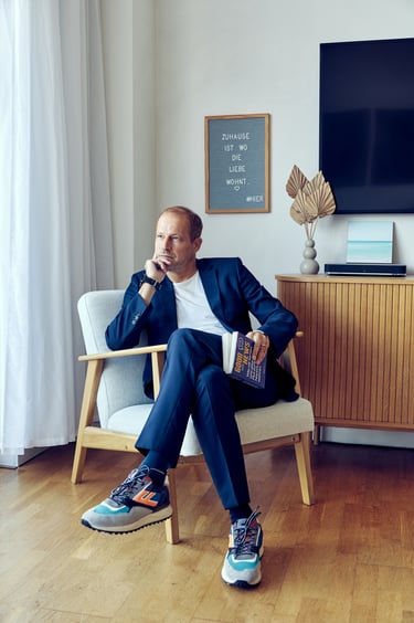 Tim Nidernolte sitting on a chair holding a book.