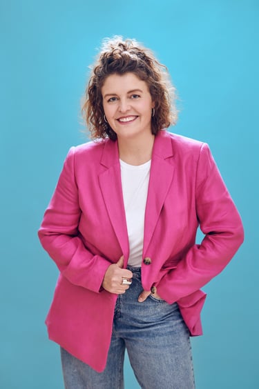Woman with a pink jacket photographed on a blue background.