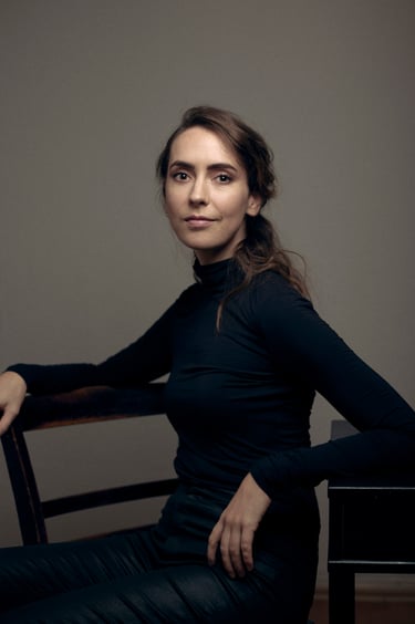A woman sitting on a chair in a photo studio.