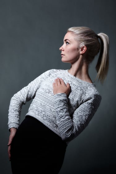 A blonde woman with a ponytail leaning backwards.