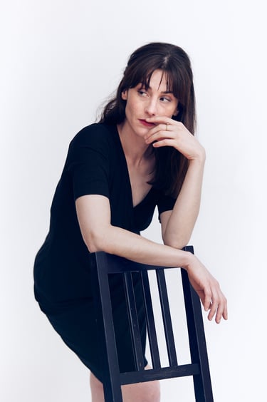 Woman looking to the side in a black dress.