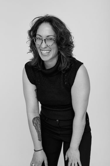 A black and white portrait of a woman laughing.