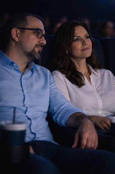 Hombre y mujer observan una película en un cine en ambiente oscuro y tranquilo