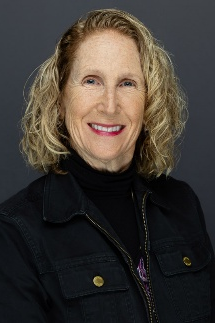 Professional headshot of Patricia Pagnotta, owner of Pagnotta Family Farm, smiling against a dark background.