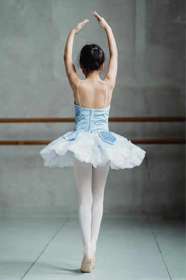 a ballerina in a ballet pose in well lite studio