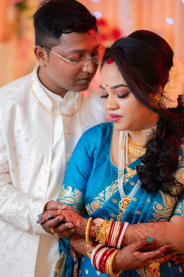 Close-up of a Bengali bride wearing traditional shakha pola bangles and gold necklaces.