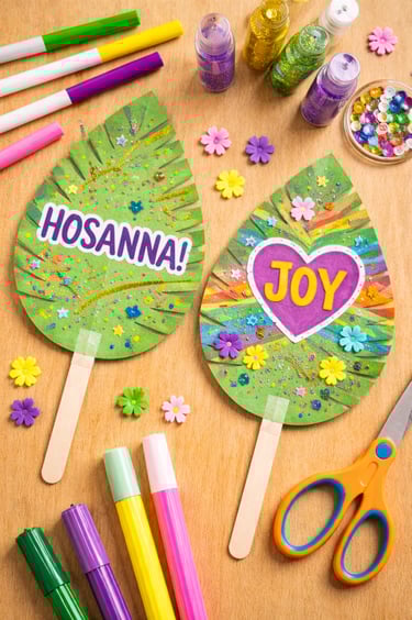 Handmade Palm Sunday paper leaf crafts with Hosanna and Joy stickers, glitter, and markers.