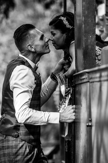 Marié regarde amoureusement sa mariée à la fenêtre de vieux train.