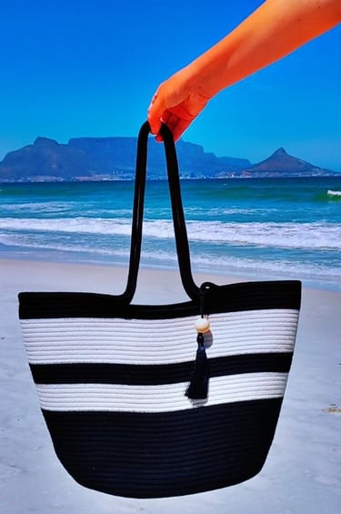 a person holding a black and white striped bag