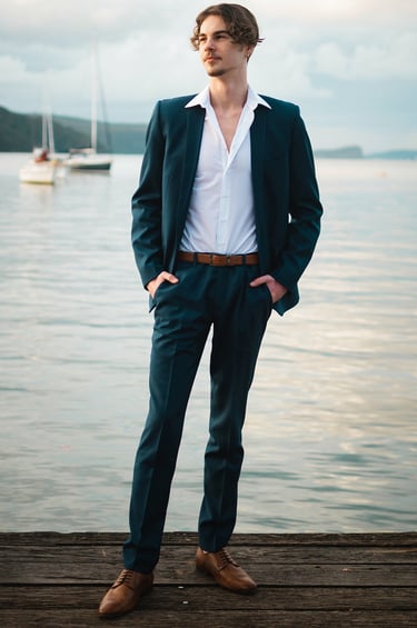 a man in a suit and tie standing on a dock