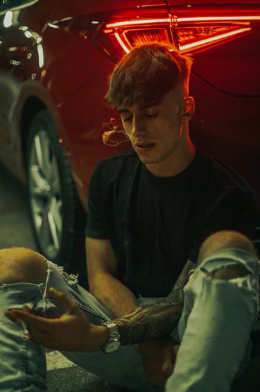 Escena en un parking oscuro con modelo y coche Seat León iluminado en rojo